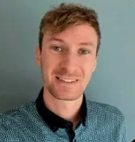 Portrait photo of a smiling man wearing a checkered shirt