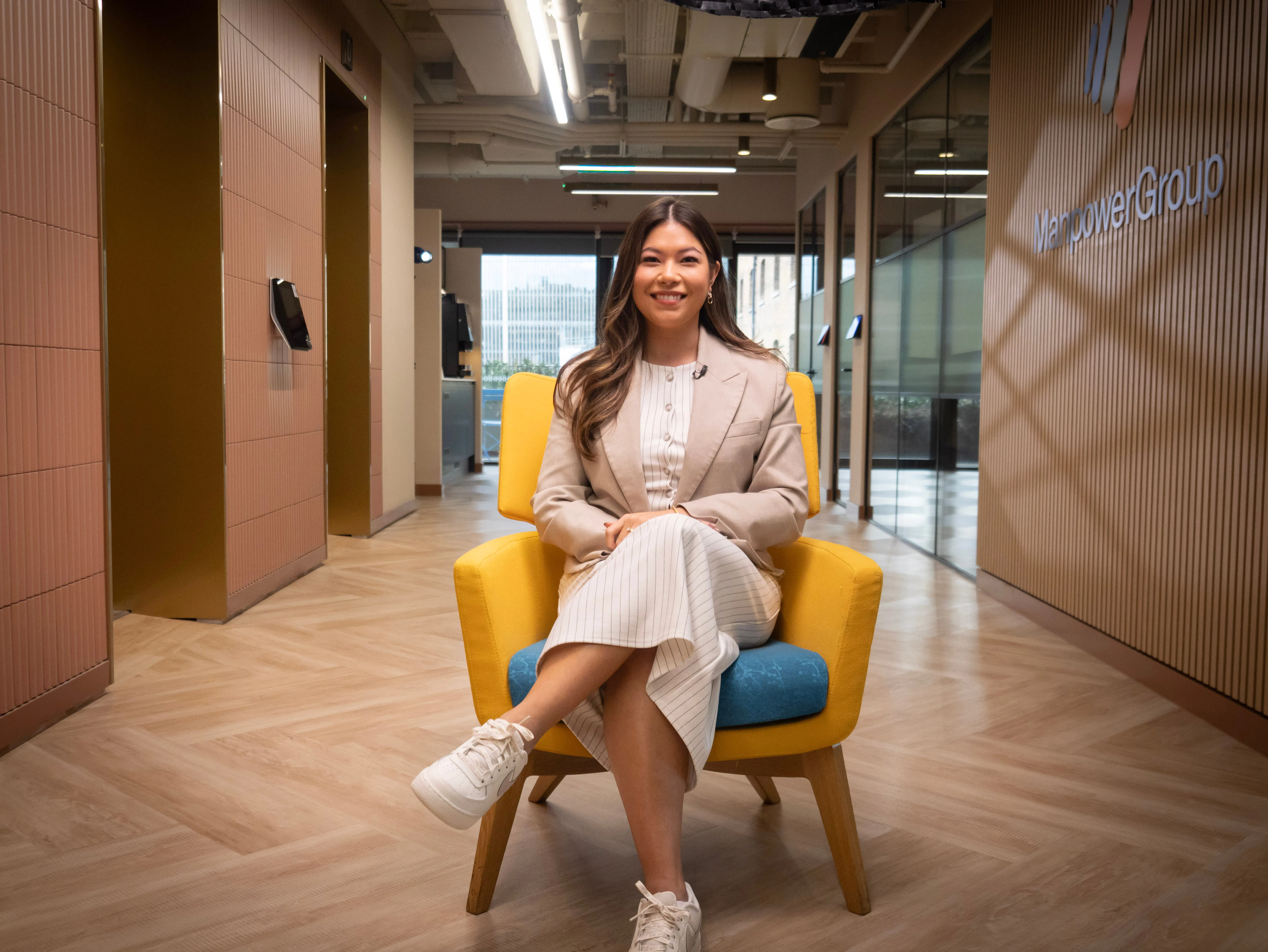 Woman smiling while seated in a ManpowerGroup office lobby