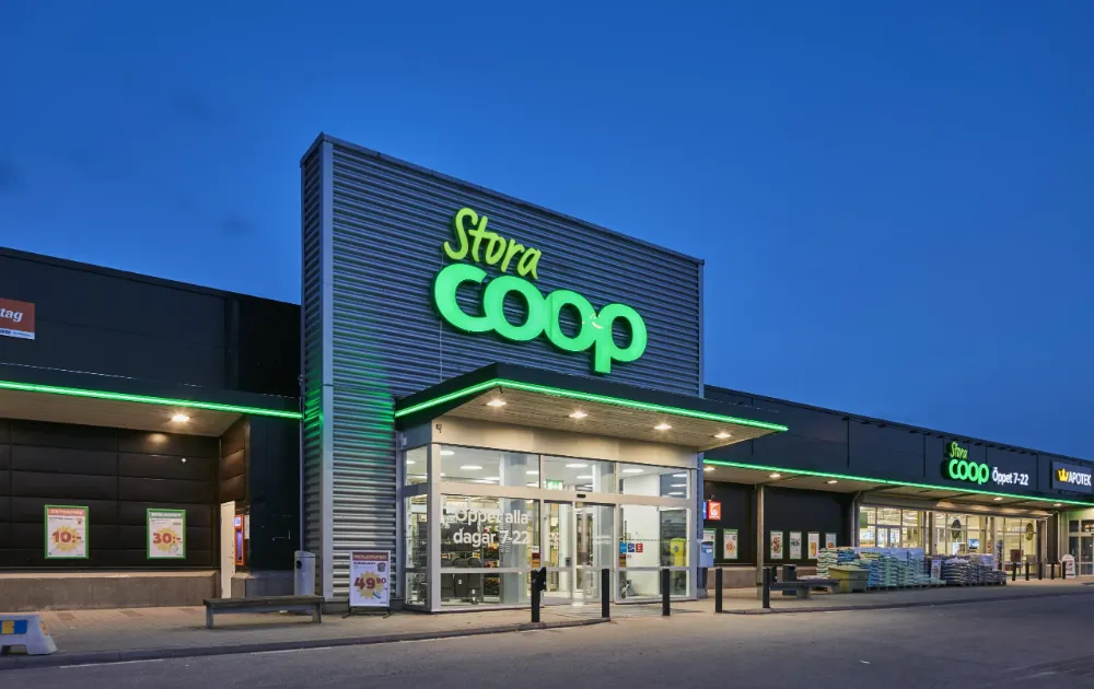 Stora Coop supermarket storefront lit up at dusk