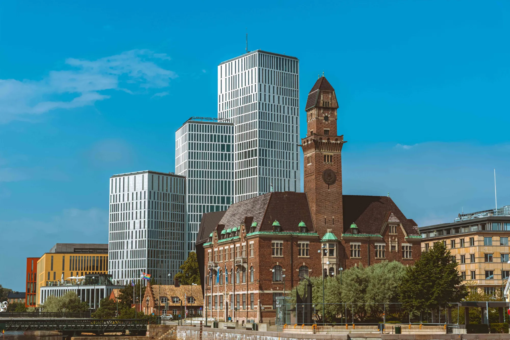 Malmö city skyline with modern high-rise buildings and a historic brick clock tower