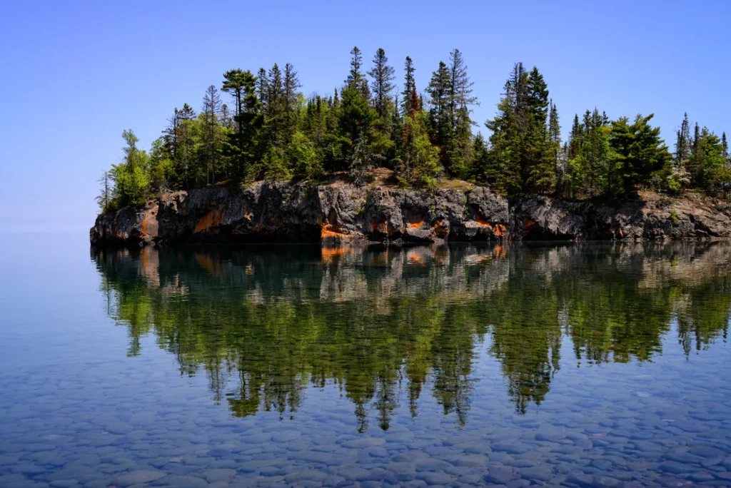 Rocky pine island reflected in Lake Superior