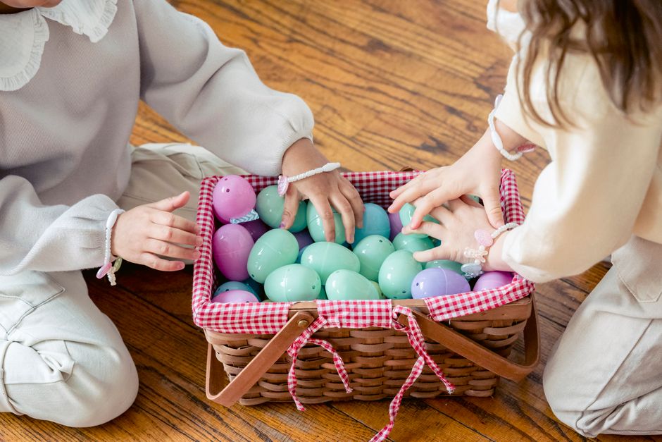 Children reaching into a basket of dyed Easter eggs