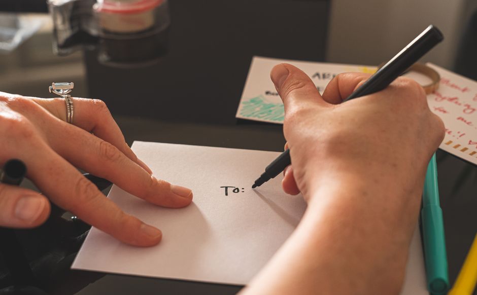 Hand writing a note in a card