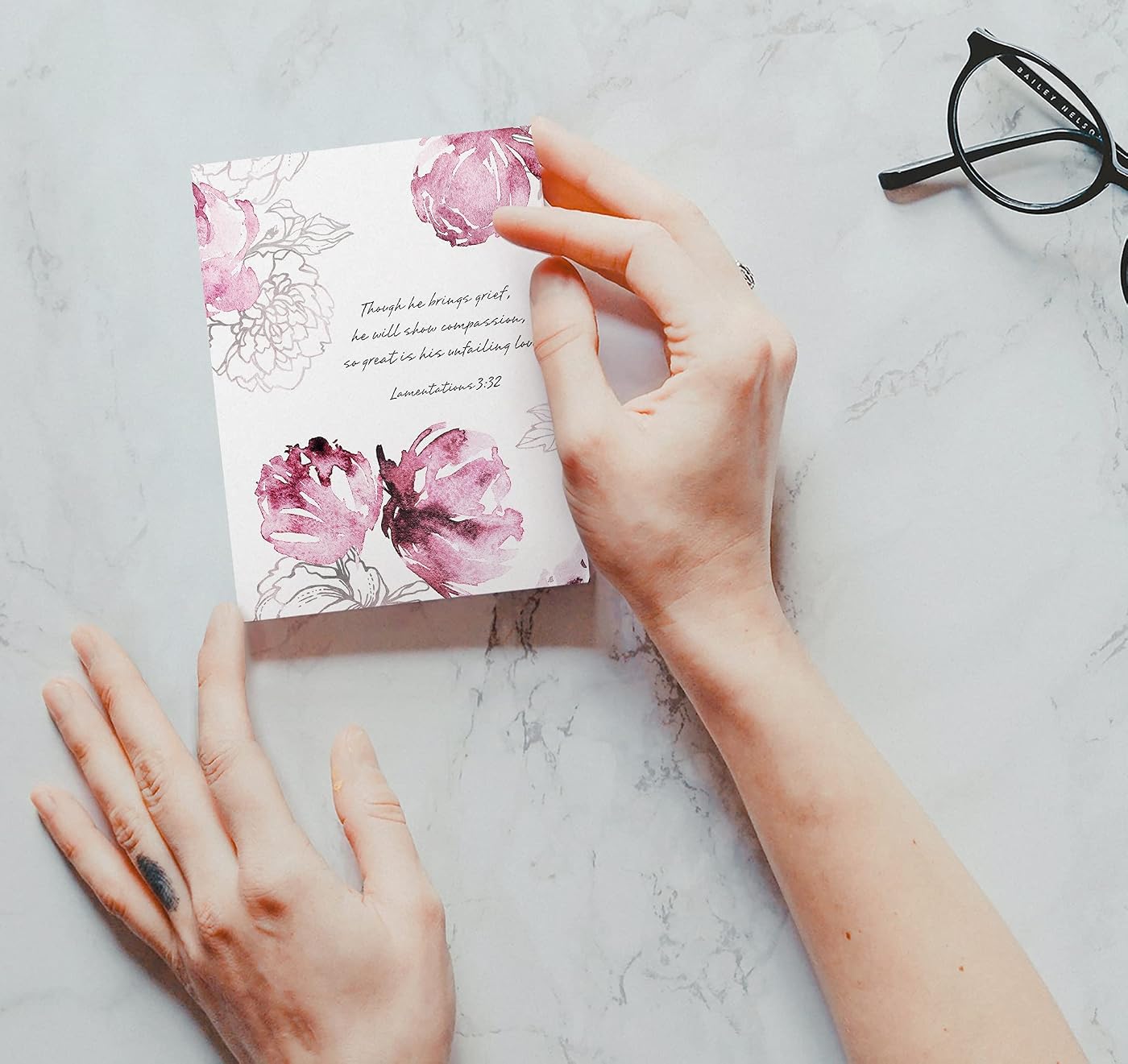 Hands holding a floral greeting card