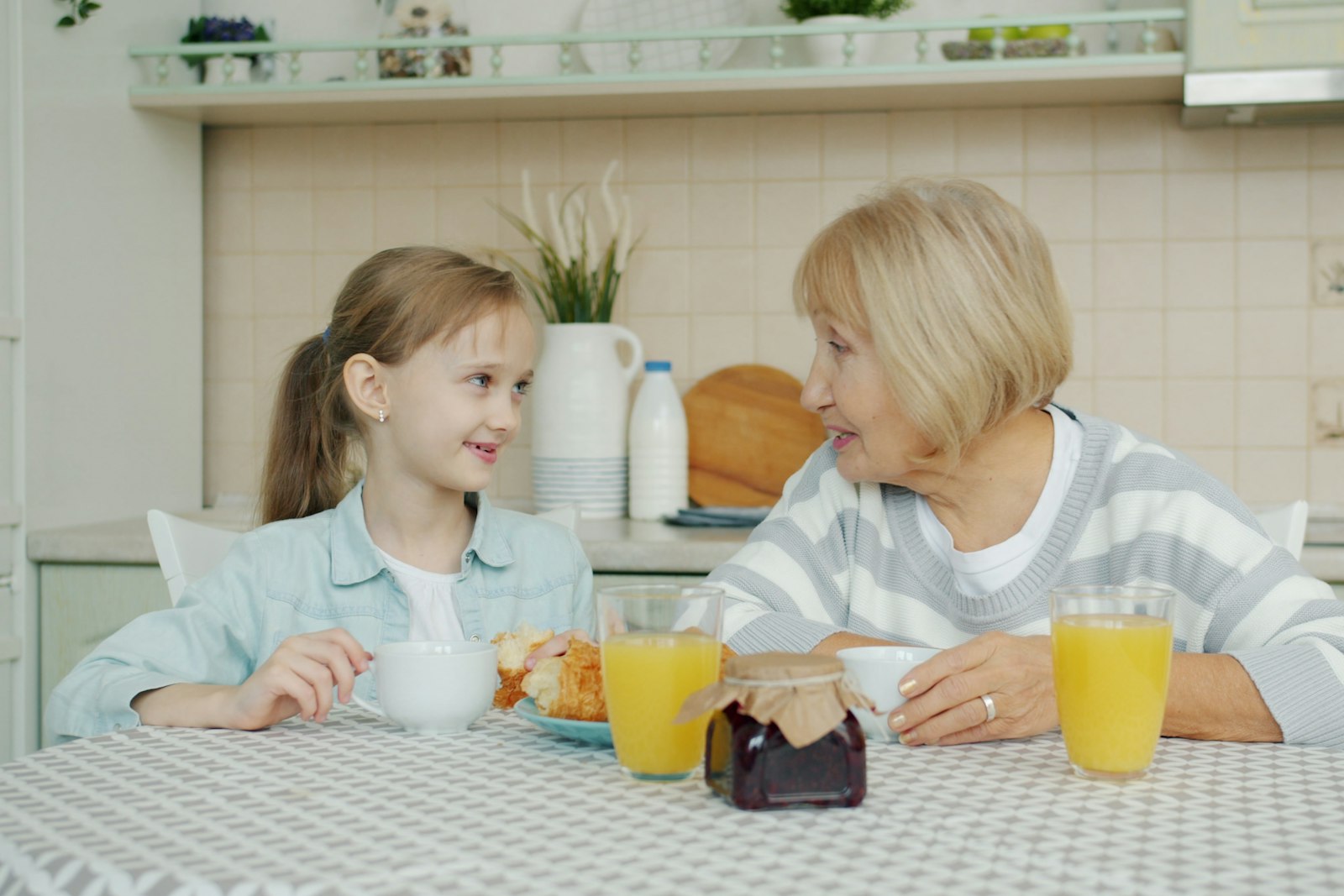 A grandmother and granddaughter talking over breakfast