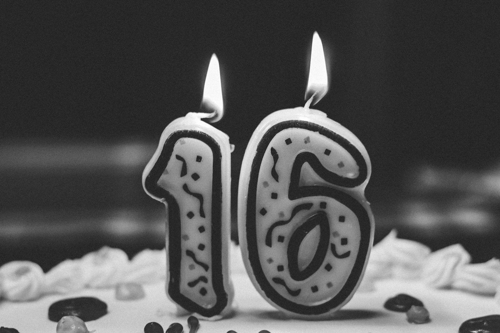 Number 16 birthday candles lit on a frosted cake