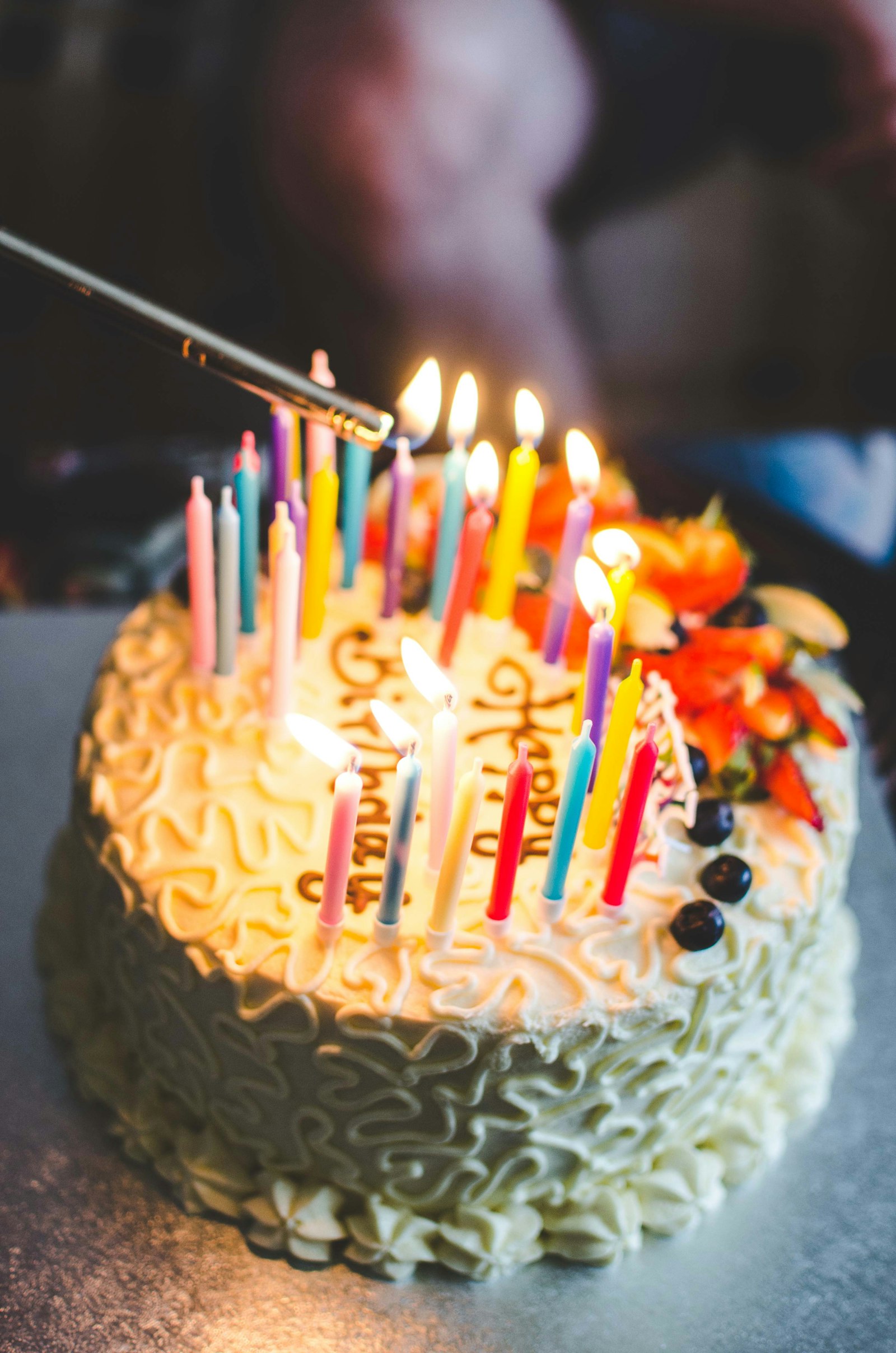 Candles being lit on a frosted birthday cake
