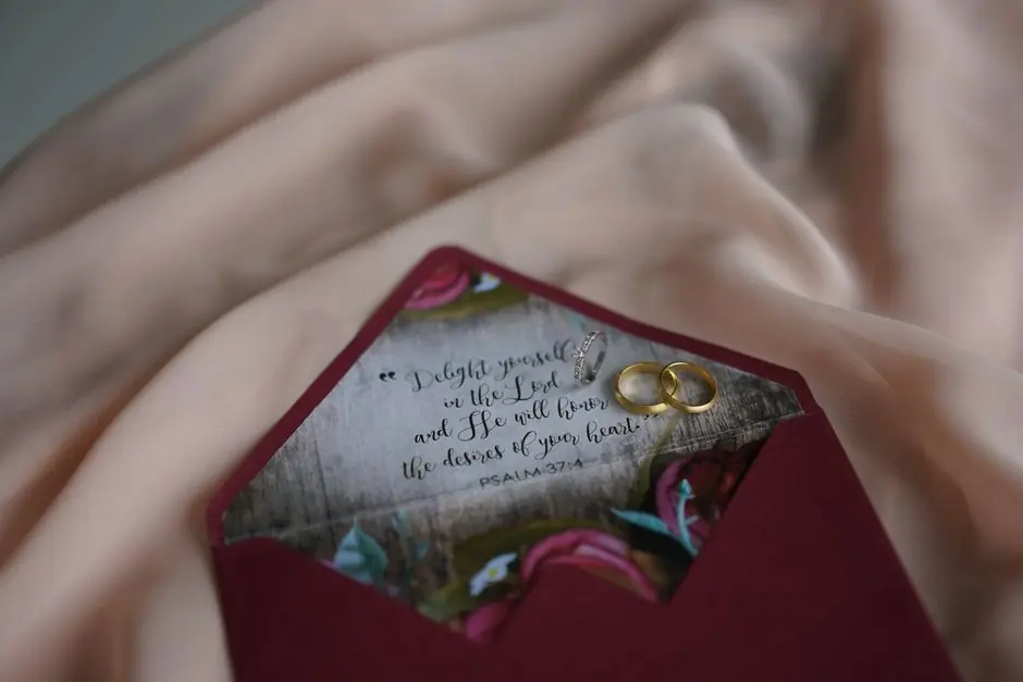 Red envelope holding a handwritten card and two rings