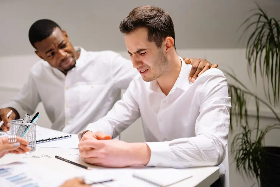 Two coworkers smiling while working together at a desk