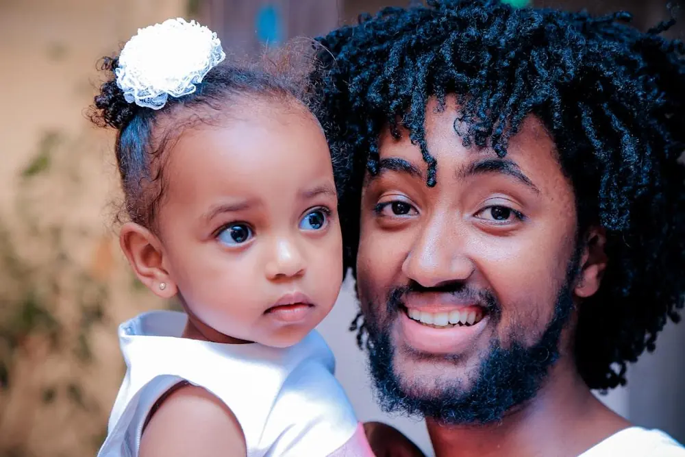 Smiling father holding his young daughter