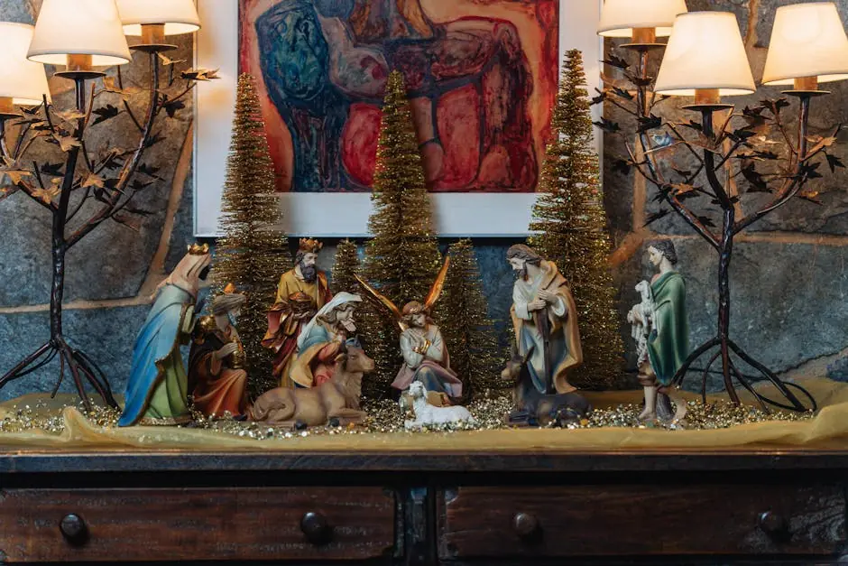 Nativity scene figures on a wooden sideboard with small gold trees