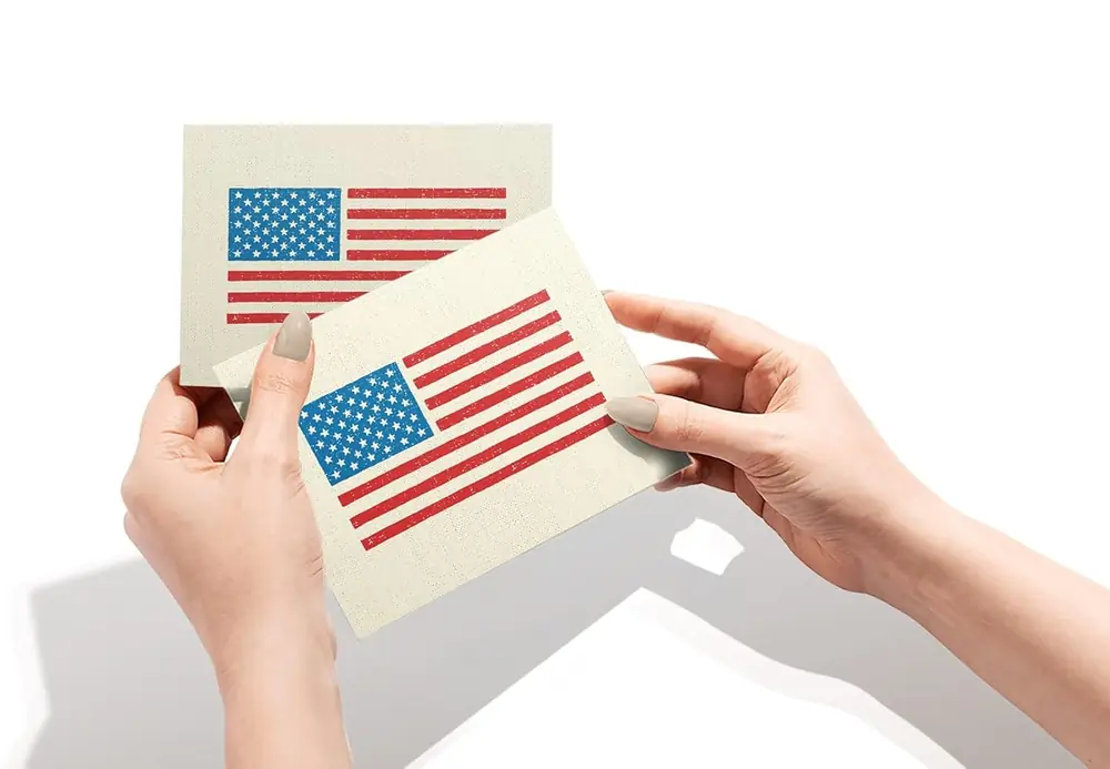Hands holding two American flag note cards