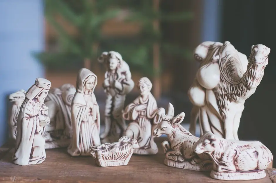 White ceramic nativity scene figures on a wooden table