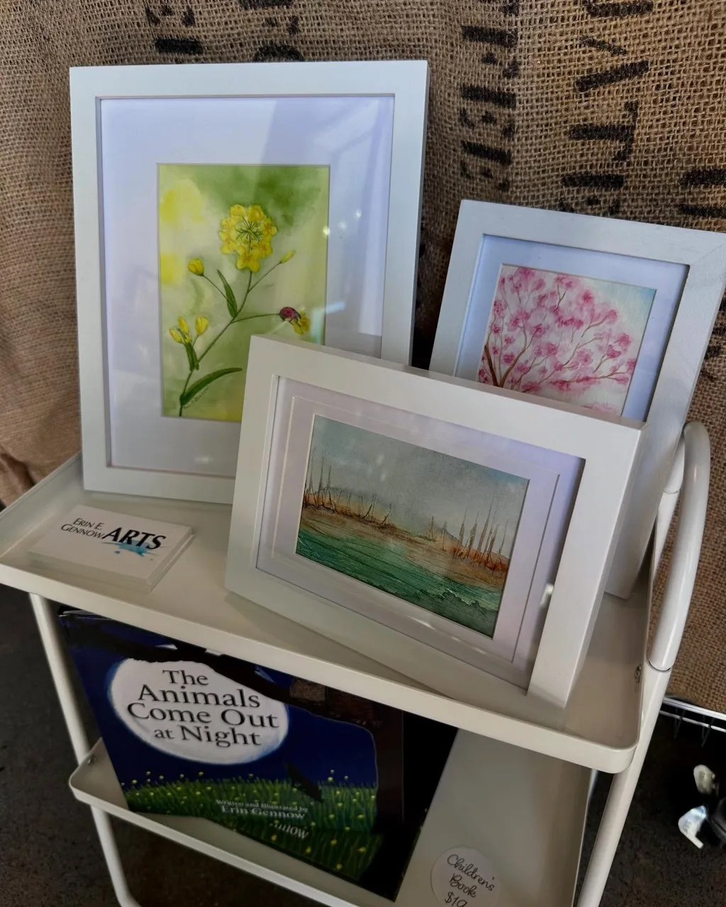 Framed watercolors of flowers displayed on a cart at Jeffries General.