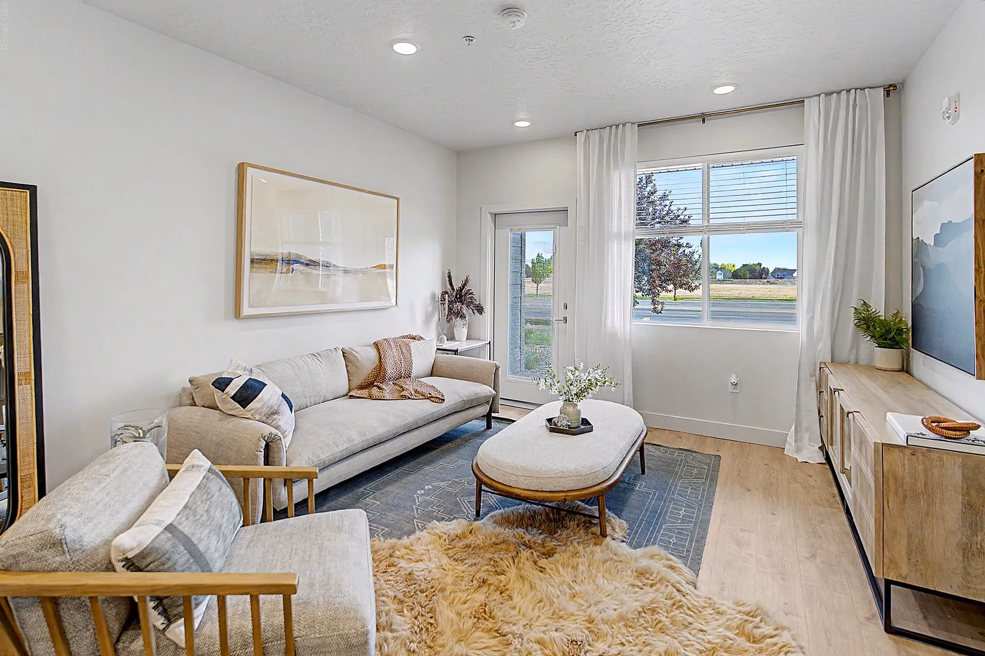 Furnished living room with large window and patio view