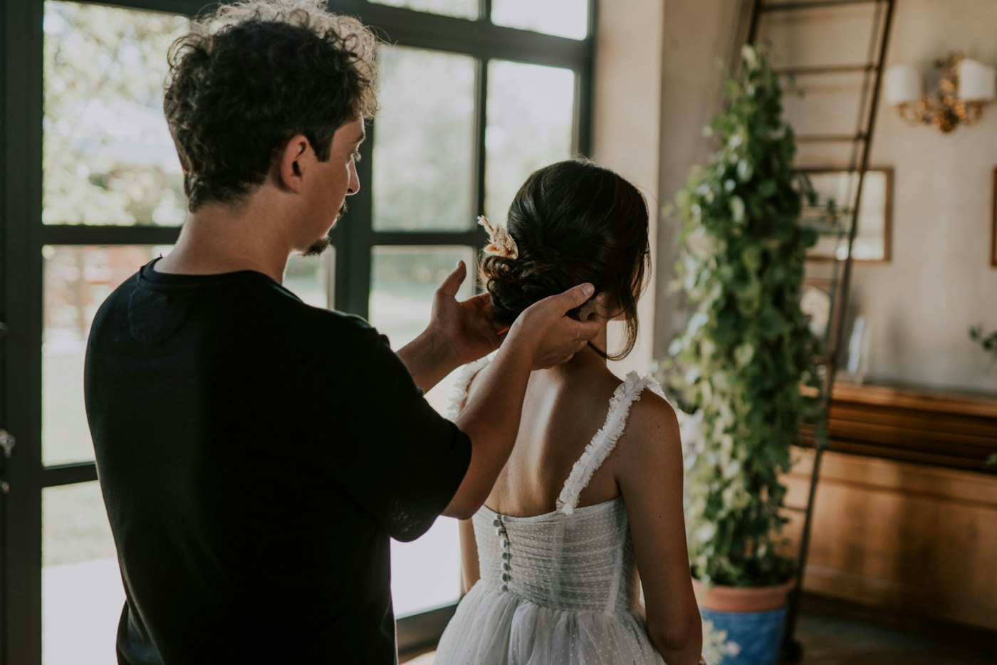 Wedding professional helping a bride into her wedding dress