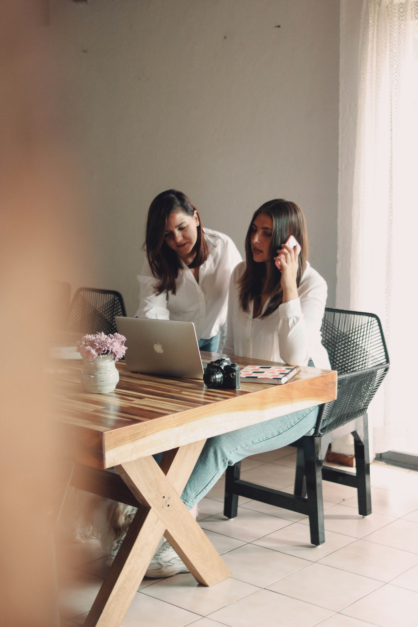 Two women working through an online course together on a laptop