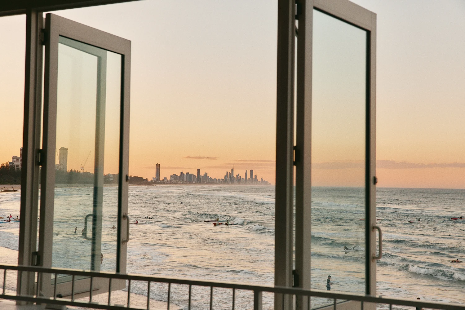 Open bifold windows framing the Surfers Paradise skyline at dusk