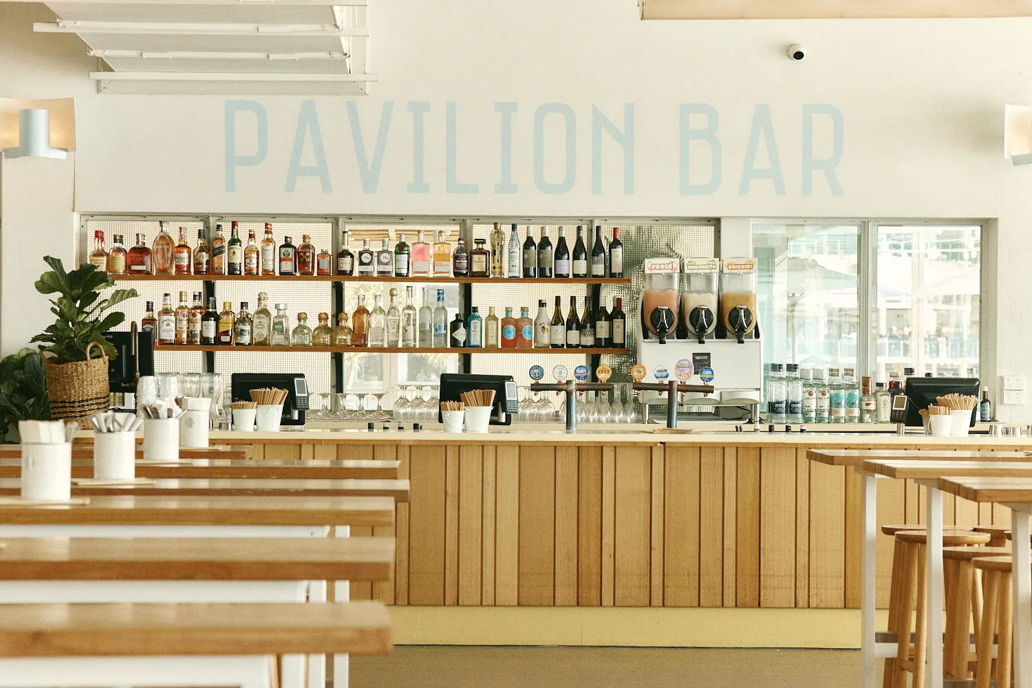 The Pavilion Bar with a timber counter and backlit spirits shelves