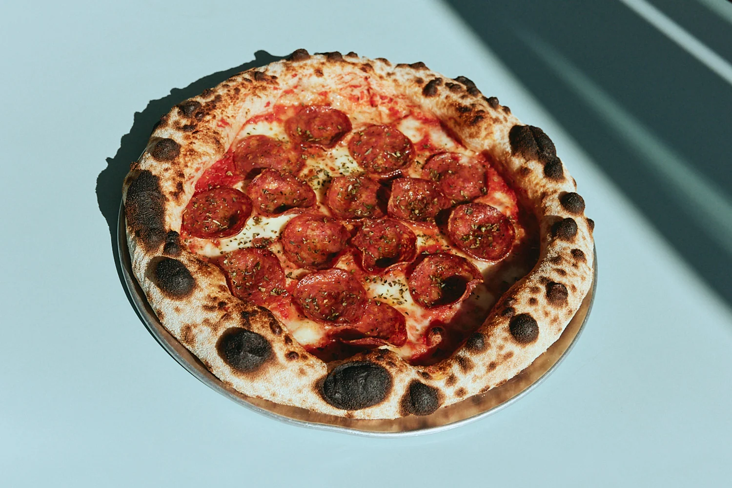 Wood-fired pepperoni pizza with a blistered crust at The Pav