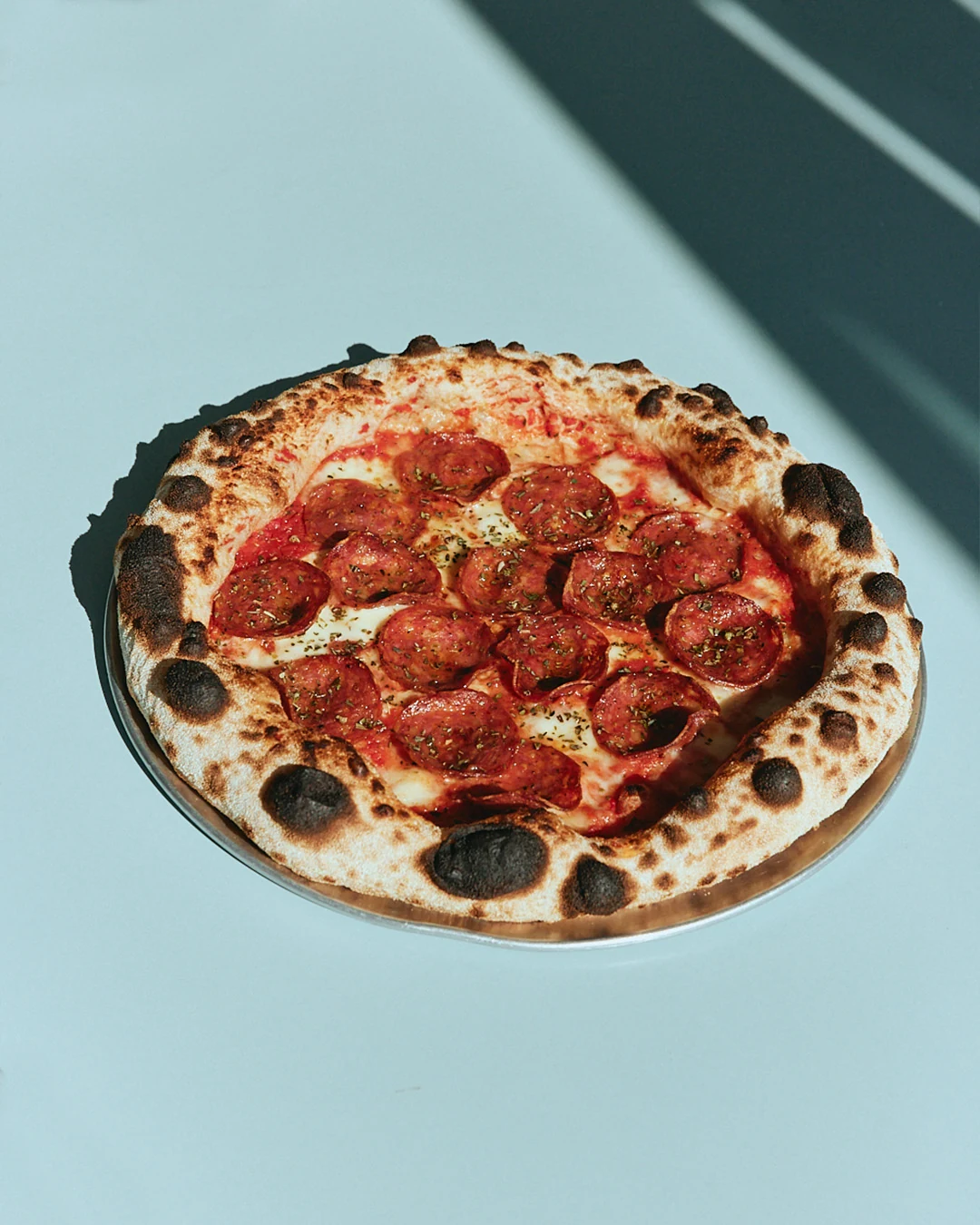 Wood-fired pepperoni pizza with a blistered crust at The Pav