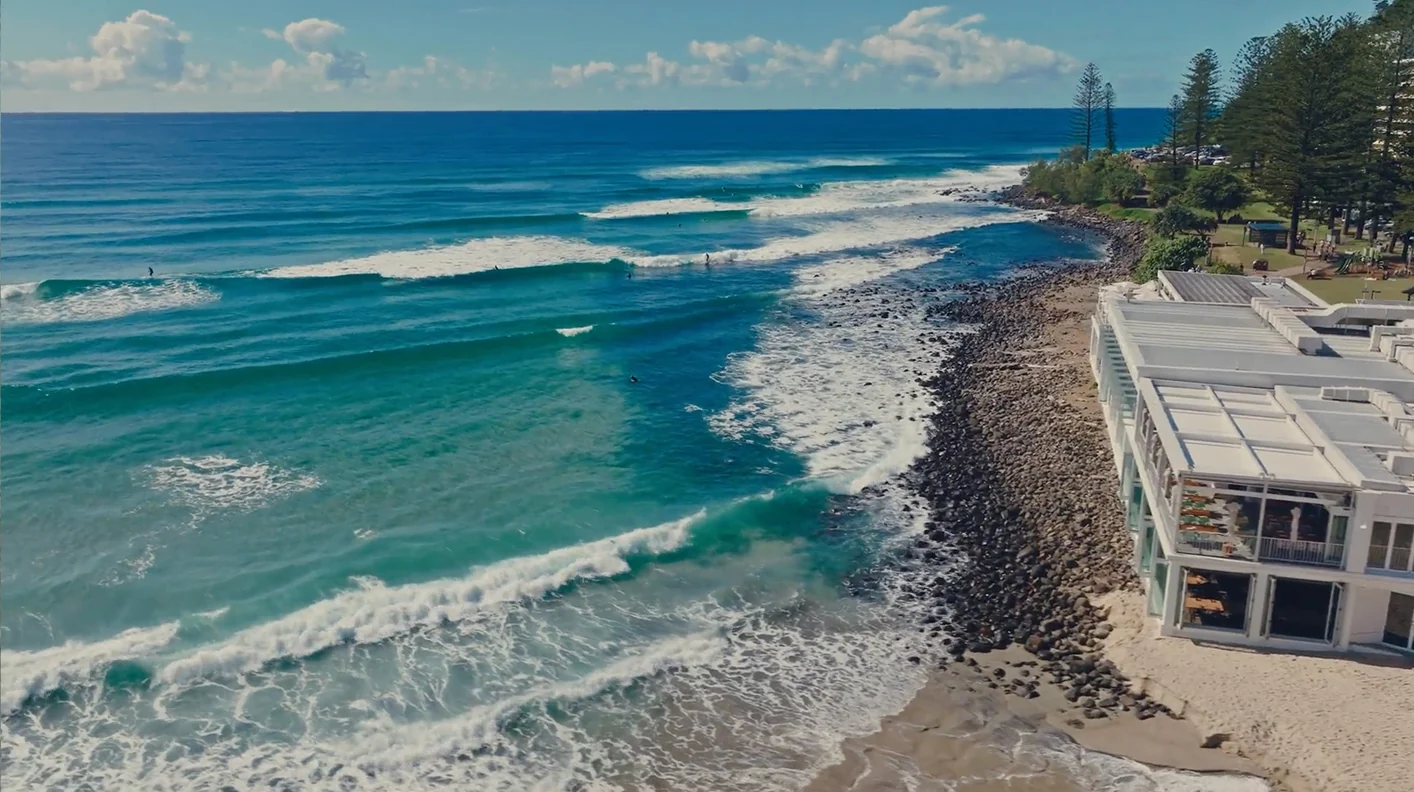 Aerial view of waves rolling along the rock wall beside Burleigh Pavilion