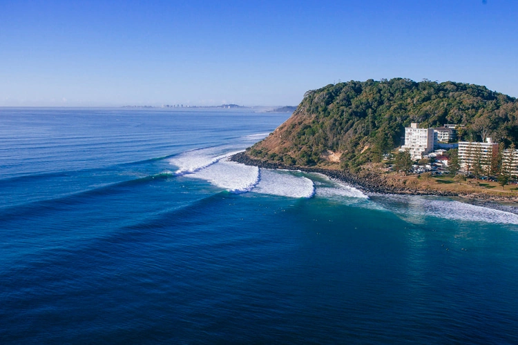 Aerial view of clean swell lines peeling around the headland at Burleigh Heads, Gold Coast