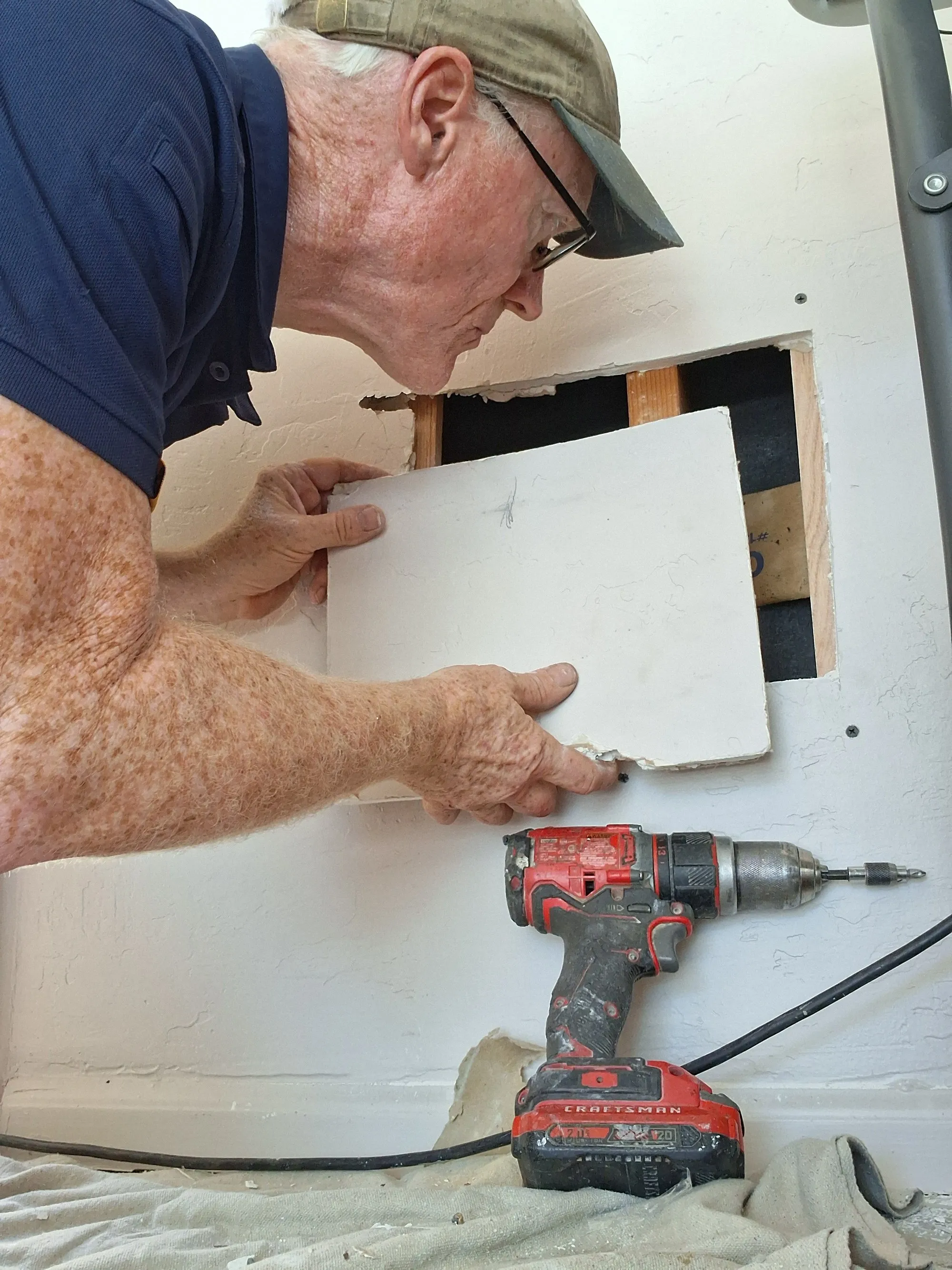 Steve Riddle patching drywall in a Tucson home