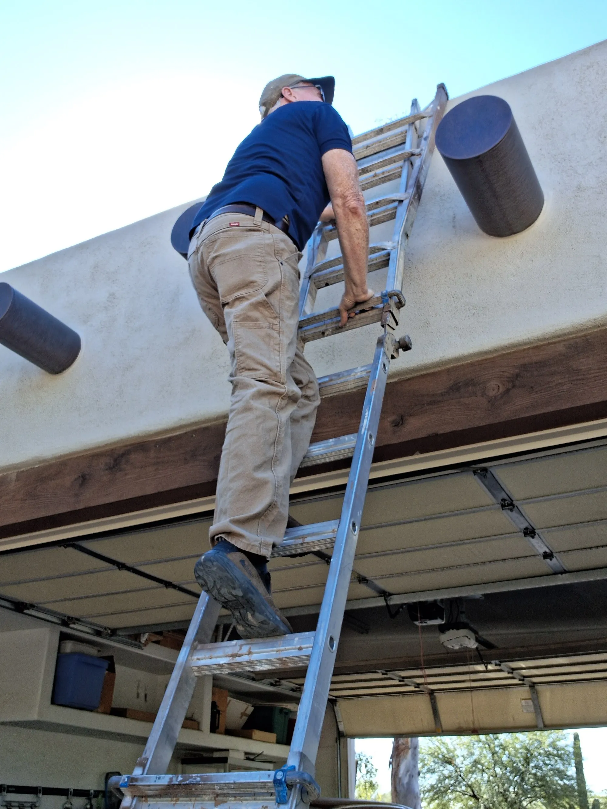 Steve Riddle on a ladder making an exterior repair