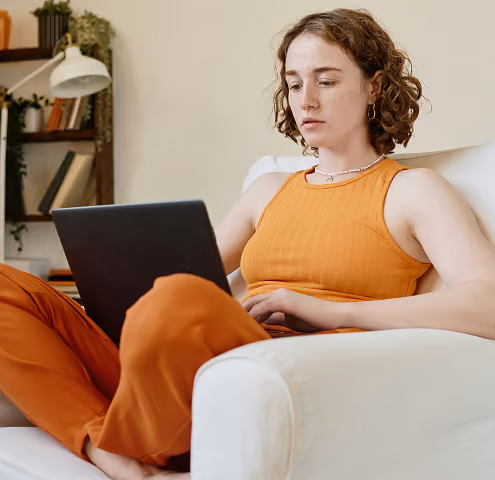 a woman blogs while sitting on a couch