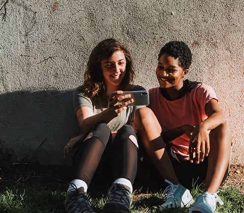 2 women look at a phone smiling