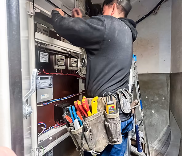 Livewire electrician working on a meter board