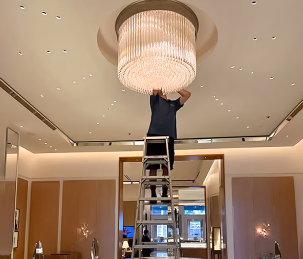 Livewire electrician installing a chandelier in a retail store