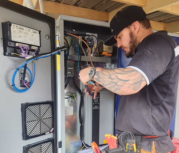 Livewire electrician wiring a commercial control panel