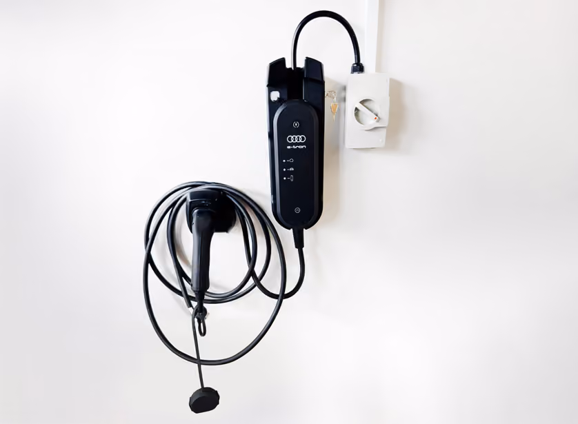 EV charging unit mounted beside its isolator on a garage wall