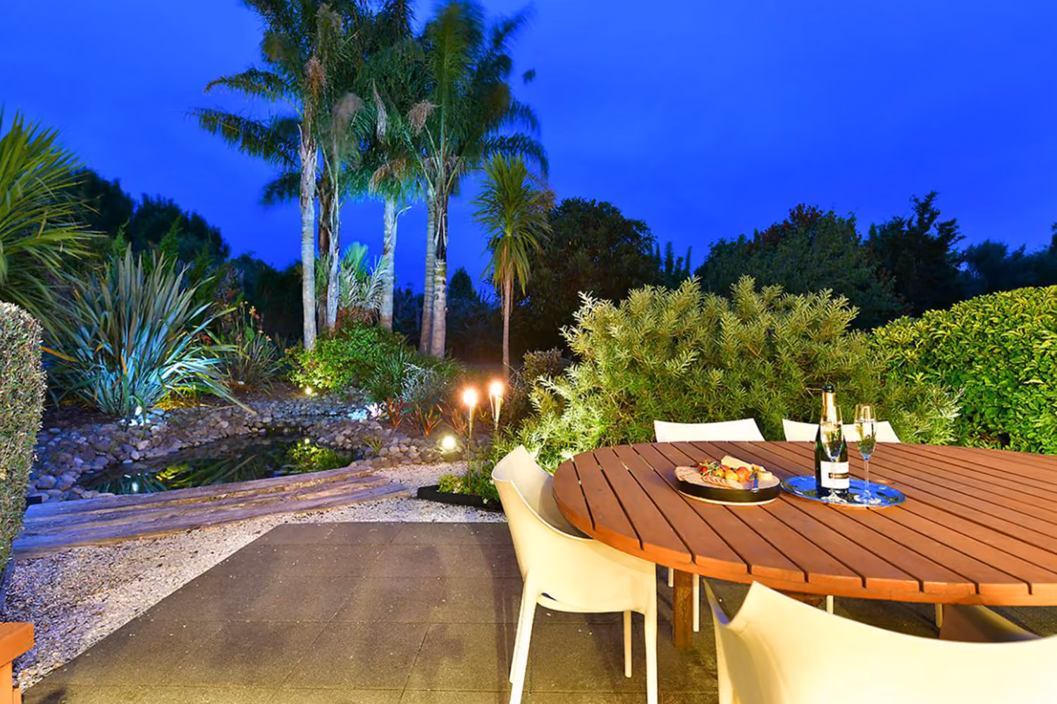 Garden and patio lighting at dusk around an outdoor dining table