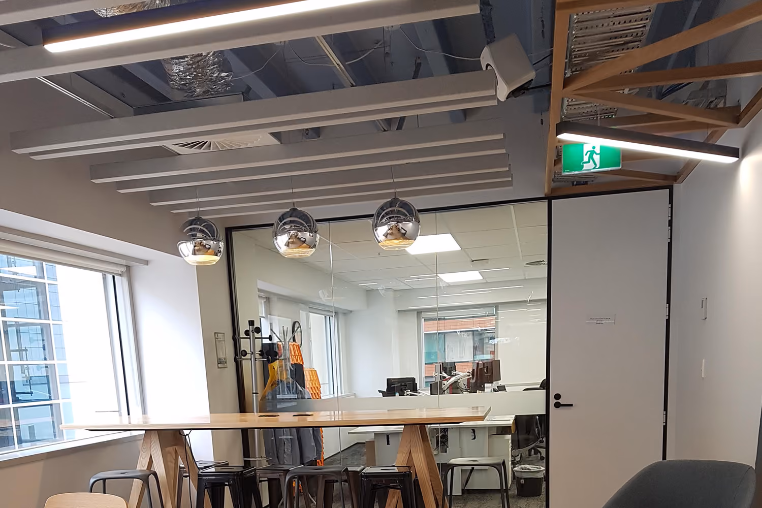 Finished office fit-out with LED panel lighting and pendant lights over a meeting table