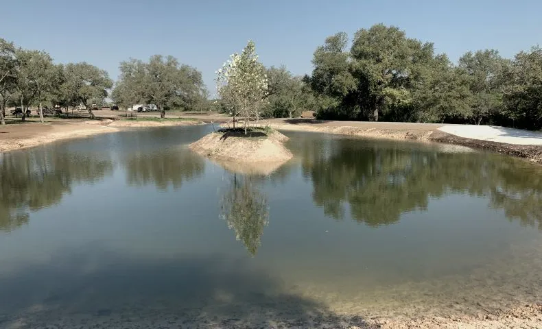 Newly built ranch pond with a tree island