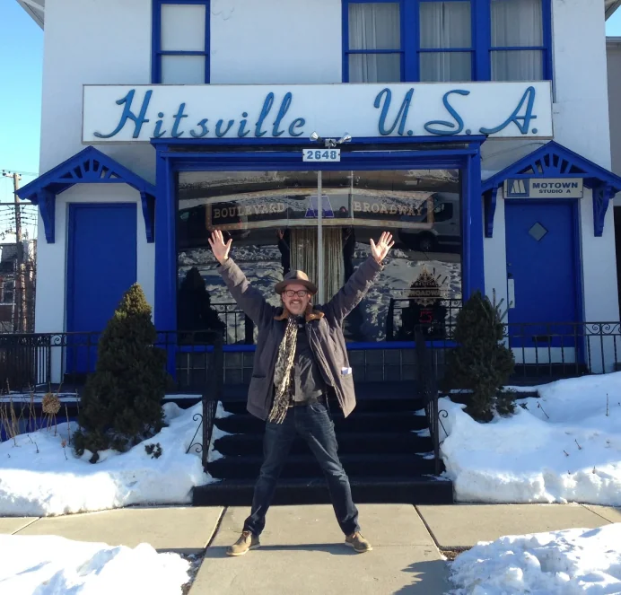 Arms raised outside Hitsville U.S.A. in Detroit, snow on the ground