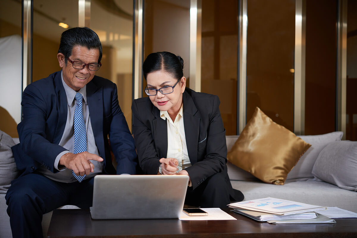 Business professionals discussing work on a laptop