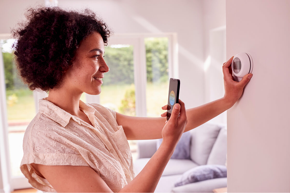 Hand adjusting a smart thermostat