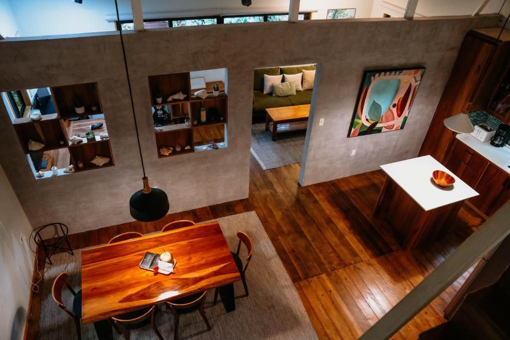 Apartamento de tres habitaciones tipo loft con comedor de madera, estanterías integradas, piso de madera y techos altos con claraboyas