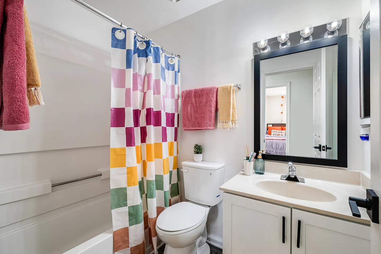 Shared bathroom with a shower and vanity