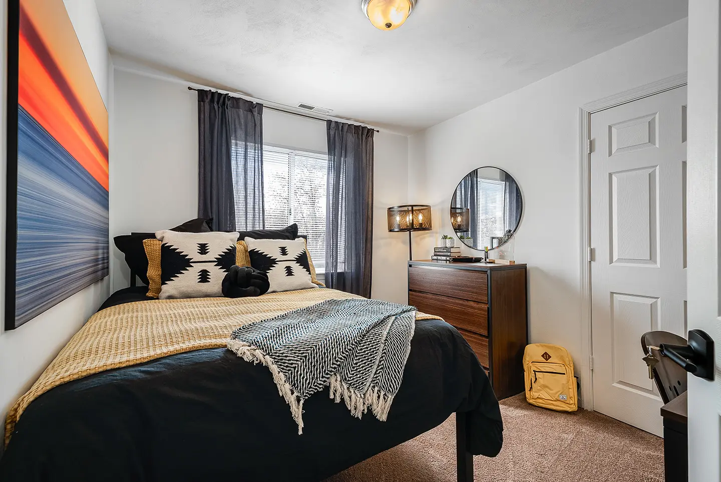 Furnished bedroom with a desk and natural light