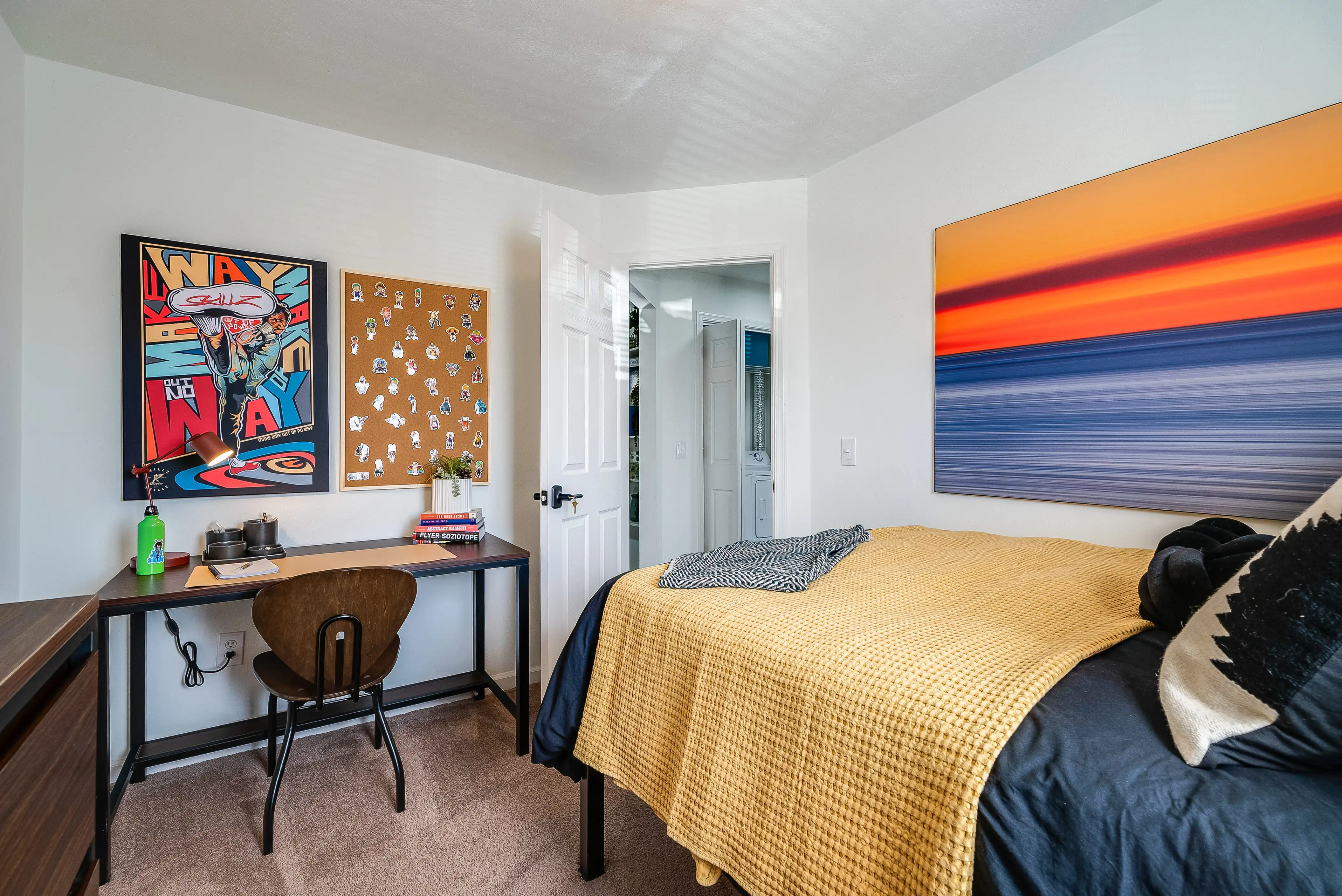 Furnished bedroom with a desk and colorful wall art