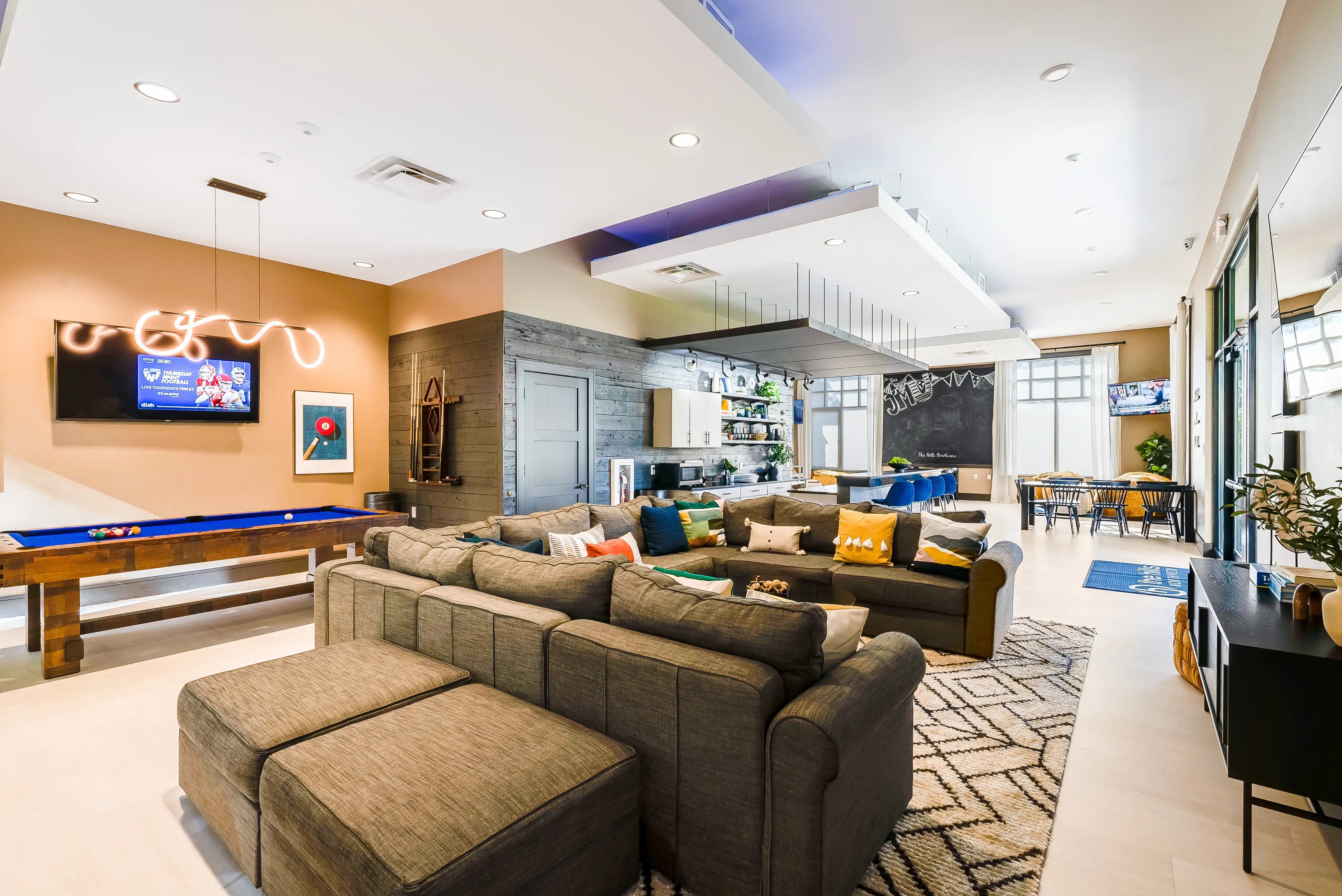Renovated clubhouse lounge with seating and TVs