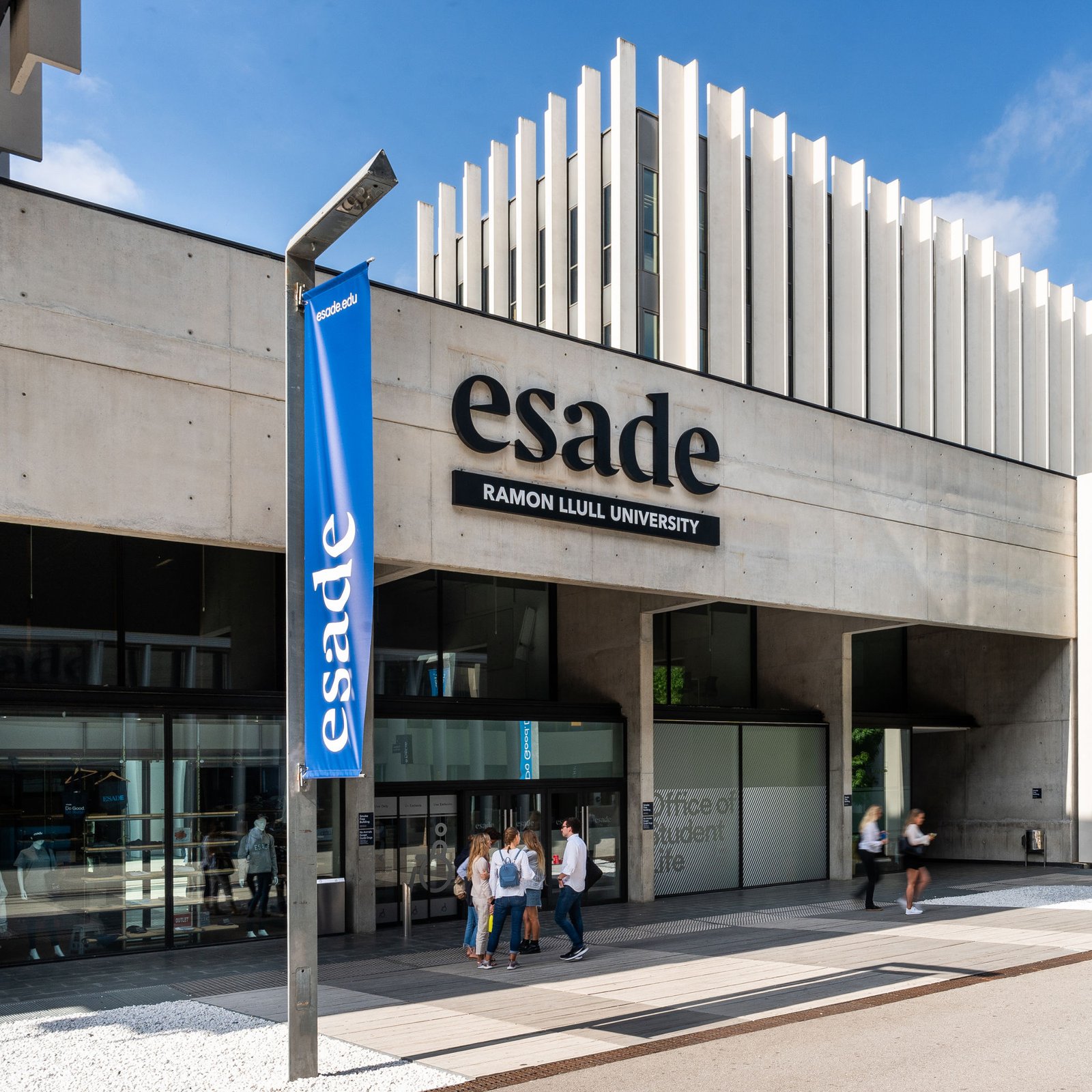 Entrance to an Esade Business School campus building with the Esade sign and blue Esade banners
