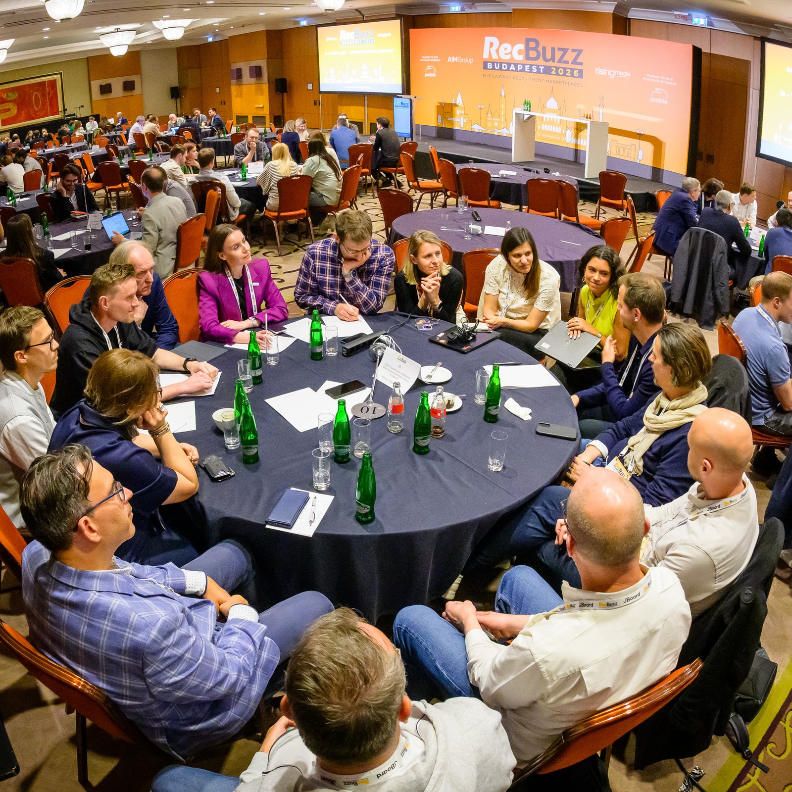 Attendees at round tables in the conference hall at RecBuzz 2026 at the InterContinental Budapest