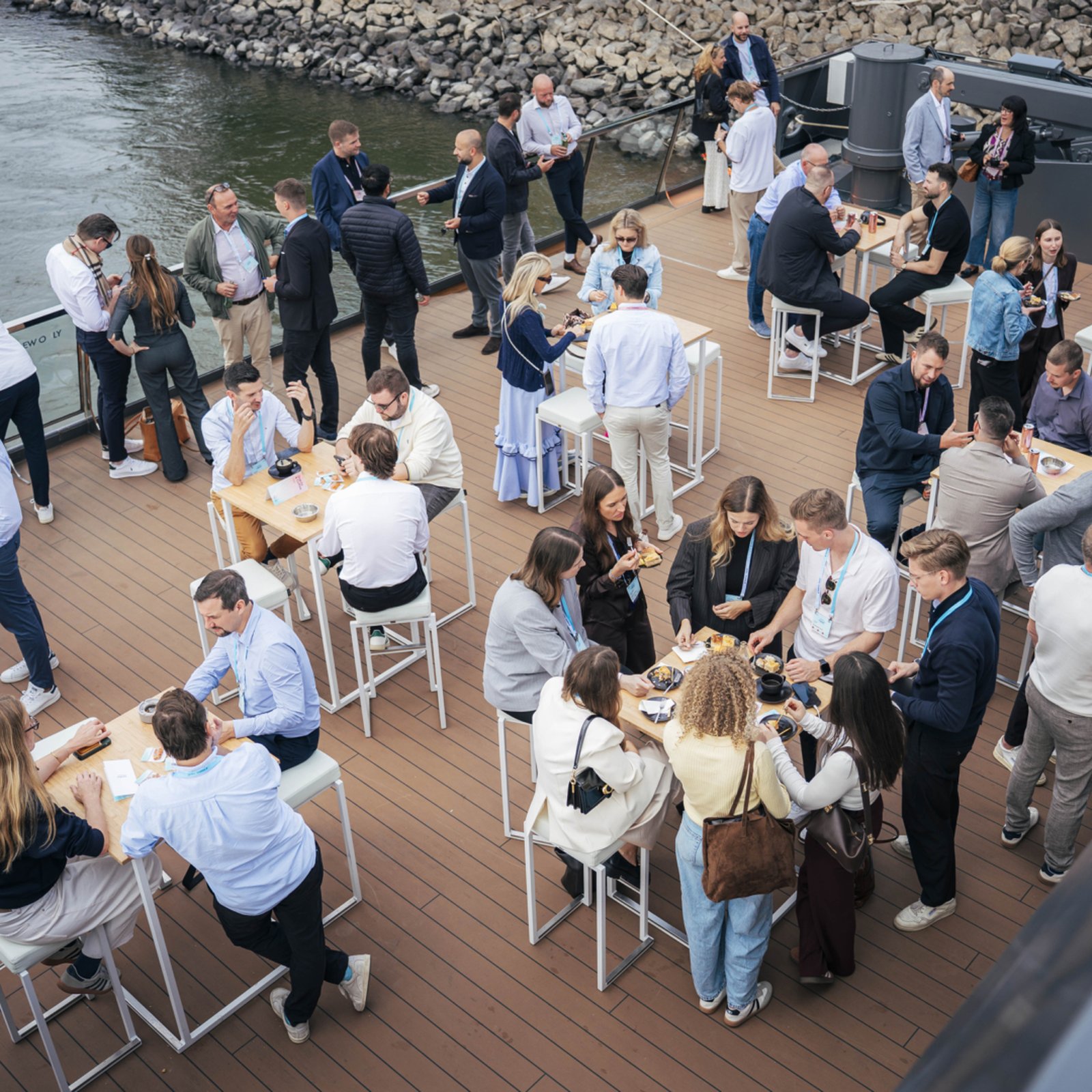 Guests networking at high tables on the deck of the Oceandiva Nova event ship at Stepstone next in Düsseldorf