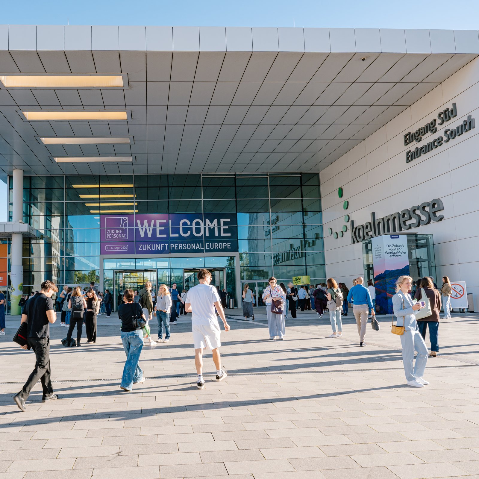 Visitors outside Koelnmesse Entrance South beneath a Welcome Zukunft Personal Europe banner in Cologne